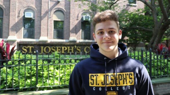 Student in front of St. Joseph's sign.